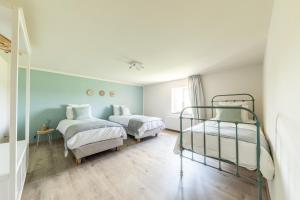 Duas camas num quarto com paredes azuis e pisos em madeira em Gîte Athois la campagne em Ath