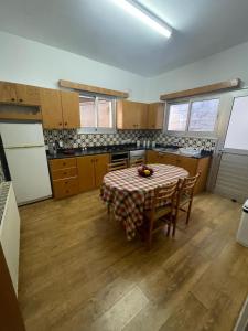 een keuken met een tafel en stoelen en een koelkast bij Casa Di Anna in Agros