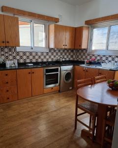 a kitchen with wooden cabinets and a table and a dishwasher at Casa Di Anna in Agros