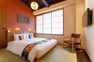 a bedroom with a bed and a chair and a window at Gion Misen Furumonzen in Kyoto