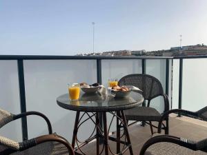 une table avec deux bols de nourriture et deux verres de jus d'orange dans l'établissement Apartamento Estepona I, à Estepona