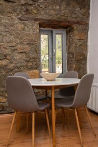 a table and chairs in a room with a stone wall at Caviro - traditional stone house in Chora in Samothraki