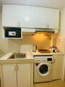 een keuken met een wastafel en een wasmachine bij 8 Spatial Condominium in Davao City