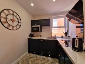 una cocina con un reloj grande en la pared en DYSA Clifton Apartments, en Lytham St Annes