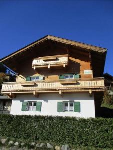 een huis met groene en witte ramen en een dak bij Ferienhaus Kaltenbrunn in Ellmau