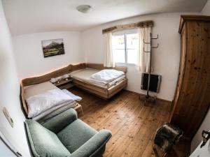 een slaapkamer met een bed, een bank en een stoel bij Ferienhaus Kaltenbrunn in Ellmau