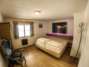 a bedroom with a bed and a chair and a window at Ferienhaus Kaltenbrunn in Ellmau