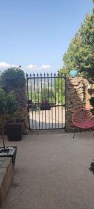 Puerta a un jardín con mesa y silla en Le gîte des Pierres Dorées, en Marcilly-dʼAzergues