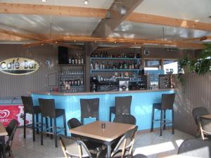 a bar in a restaurant with tables and chairs at Camping Haliotis in Pontorson