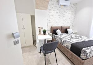 a bedroom with a bed and a desk and a chair at B&B Tra le vie del borgo in Vieste