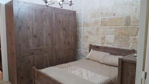 una camera con un letto e una parete in legno di Dar il-Hena a Żurrieq