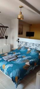 1 dormitorio con 1 cama con manta azul en Le gîte des Pierres Dorées, en Marcilly-dʼAzergues