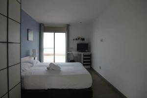 a bedroom with a large white bed and a window at VILLA MARICEL in Alcanar +17 photos