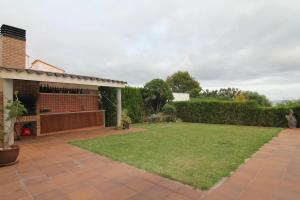 a backyard with a lawn and a brick building at VILLA MARICEL in Alcanar