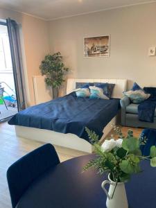 a bedroom with a large blue bed and a table at Wiślane Tarasy 2.0, free parking, private garden in Kraków +9 photos