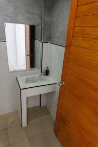 a bathroom with a sink and a mirror at Isla Tortuga Diving & Hostel in Ko Tao