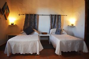 a room with two beds and a table and two lamps at Casa KiSi Cottage, Rural Boutique Bed & Breakfast in Málaga