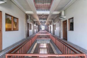 バンジャルマシンにあるUrbanview Hotel Kanca Banjarmasin by RedDoorzの古い建物内の空廊 +3枚の写真