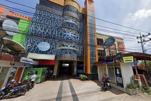 バンジャルマシンにあるUrbanview Hotel Kanca Banjarmasin by RedDoorzの前に人乗りする建物