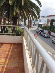 un balcón con una palmera y una calle en Apartamento la concha Suances, en Suances