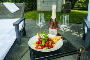 einen Teller mit Gemüse und eine Flasche Wein auf dem Tisch in der Unterkunft Wirtshaus Leindl in Krems an der Donau
