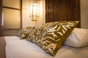 a bed with brown and white pillows and a lamp at K-TERRA by Nuka Homes in Jávea
