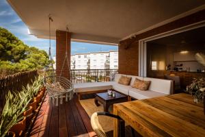 a balcony with a white couch and a wooden table at K-TERRA by Nuka Homes in Jávea