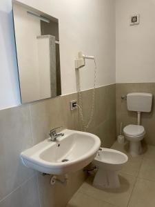W łazience znajduje się umywalka, toaleta i lustro. w obiekcie Villa Franca w mieście Santa Flavia