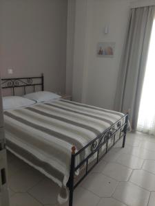 a bedroom with a large bed with a striped blanket at Alkyon Hotel in Kamari