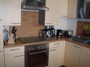 a kitchen with white cabinets and a stove top oven at Ferienhaus Silvia 