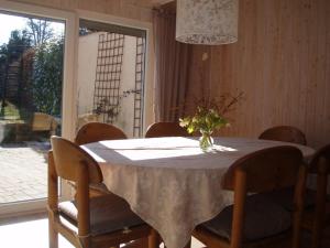 una mesa de comedor con un jarrón de flores. en Ferienhaus Silvia 