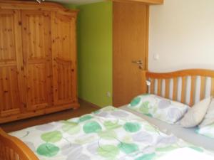 uma cama com um edredão verde e branco num quarto em Ferienhaus Silvia 