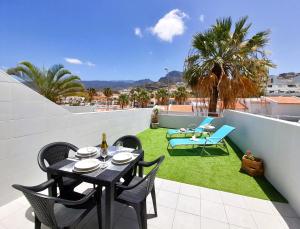 a patio with a table and chairs on a roof at Lovely apartment Costa Adeje & Big Terrace in Adeje