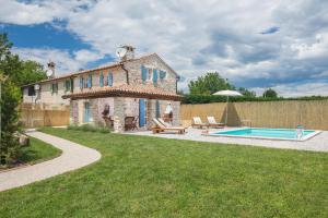 an old stone house with a swimming pool in a yard at Villa Ivea in Višnjan
