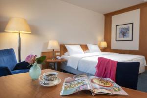 a hotel room with a bed and a table with a book at Maritim Hotel Frankfurt in Frankfurt