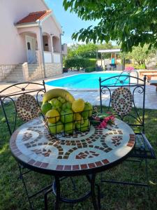 a table with a basket of fruit on it at Villa Marta in Murvica