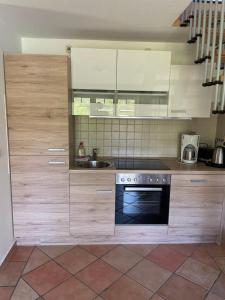 a kitchen with white cabinets and a stove and a sink at Ferienwohnung Möwe in Graal-Müritz