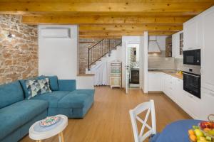 a living room with a blue couch and a kitchen at Villa Ivea in Višnjan
