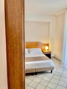 ein Schlafzimmer mit einem Bett mit einem Kopfteil aus Holz in der Unterkunft Villa Franca in Santa Flavia