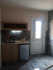 cocina con fregadero y puerta con ventana en Villa Hellas, en Afiartis