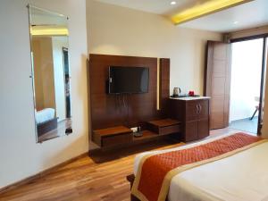 a hotel room with two beds and a television at Mastiff Hotel, Dalhousie in Banikhet