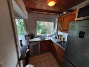 a kitchen with a sink and a refrigerator and a window at Dom Letniskowy, Siła in Sila