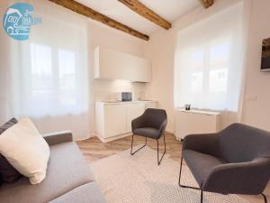 奧皮奇納村的住宿－Basovizza 3 Alessandro Tirabora Short Rent，客厅配有沙发和两把椅子