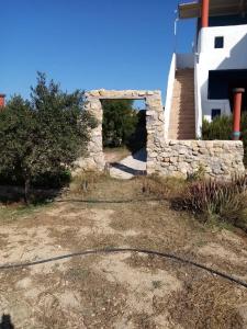 un edificio con una pared de piedra junto a un patio en Villa Hellas, en Afiartis