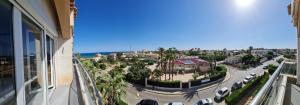 弗拉門戈海灘的住宿－- - - - - FRONT LINE - - - - - Primera Línea - - - - - Apartments in Playa Flamenca，享有市景,在街道上停放车辆