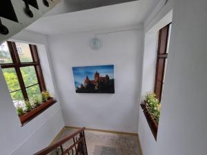 a hallway with two windows and a picture of a castle at Central Park Apartments in Cluj-Napoca