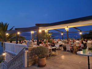 a restaurant with people sitting at tables at night at Hotel Vila Tina in Trogir