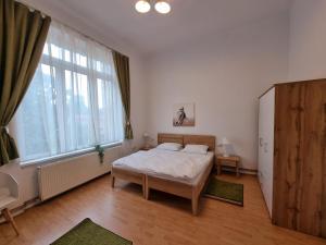 a bedroom with a bed and a large window at Central Park Apartments in Cluj-Napoca