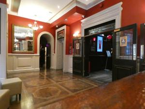 a bar in a restaurant with red walls and a counter at Jackson Court Hotel in Dublin