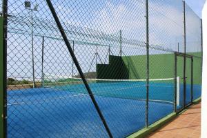 un campo da tennis visto attraverso una rete di rete di 2 bedrooms apartement with shared pool enclosed garden and wifi at La Canada a La Cañada de San Urbano